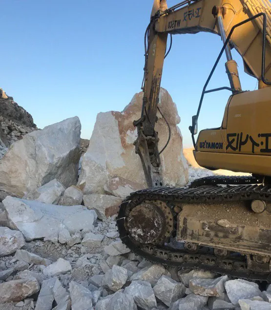 Excavator breaking stone at a Magma Ma'dan Arya quarry